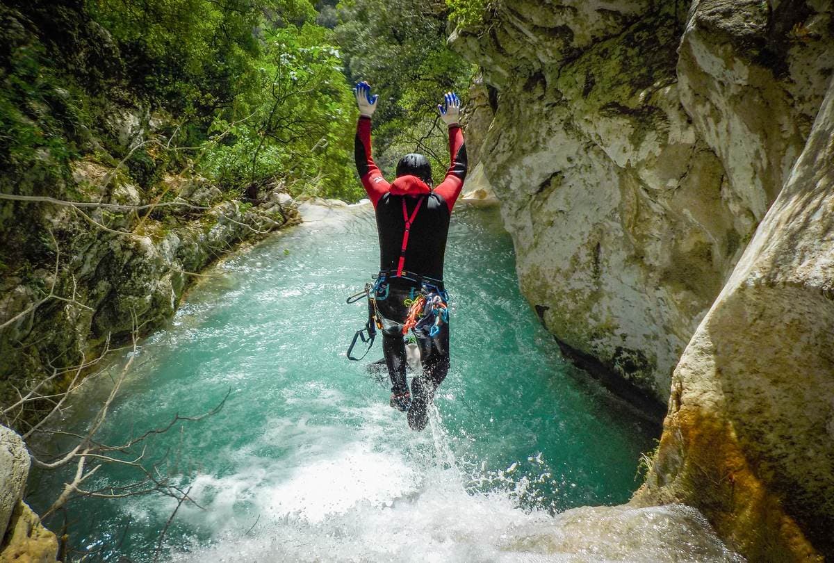 Canyoning in Greece with a guide jumping into the turquoise waterfalls of the Neda river.