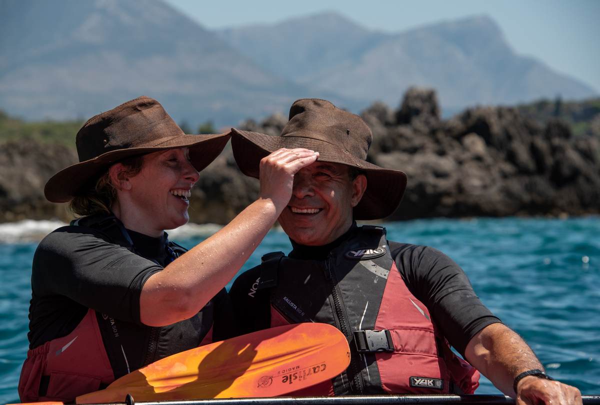 Couple in sun hats laughing and enjoying a sunny day on the water