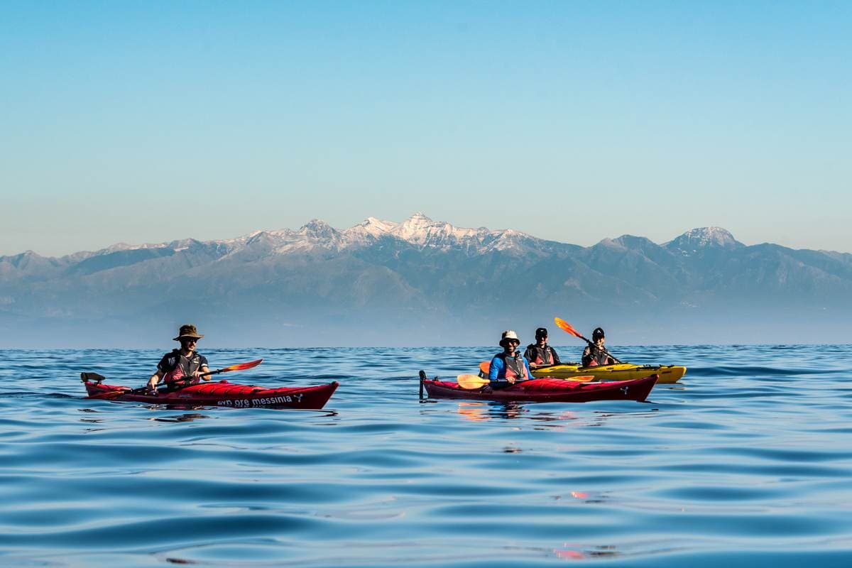 Group paddling in calm water with the Taygetos mountains in the background near Monemvasia