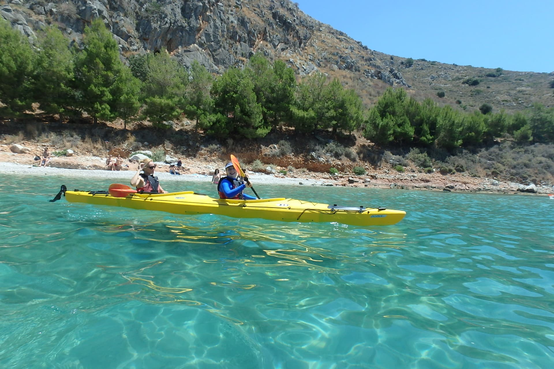 Tandem kayak in shallow turquoise water near the shore on a Sea Kayaking Nafplio tour