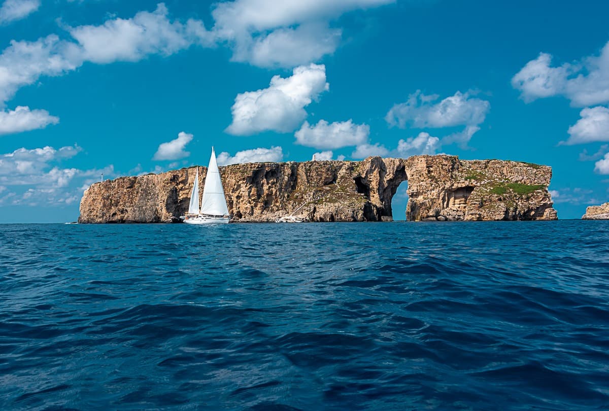 Sea kayaking in Greece through the natural rock arch of Navarino Bay near Pylos.
