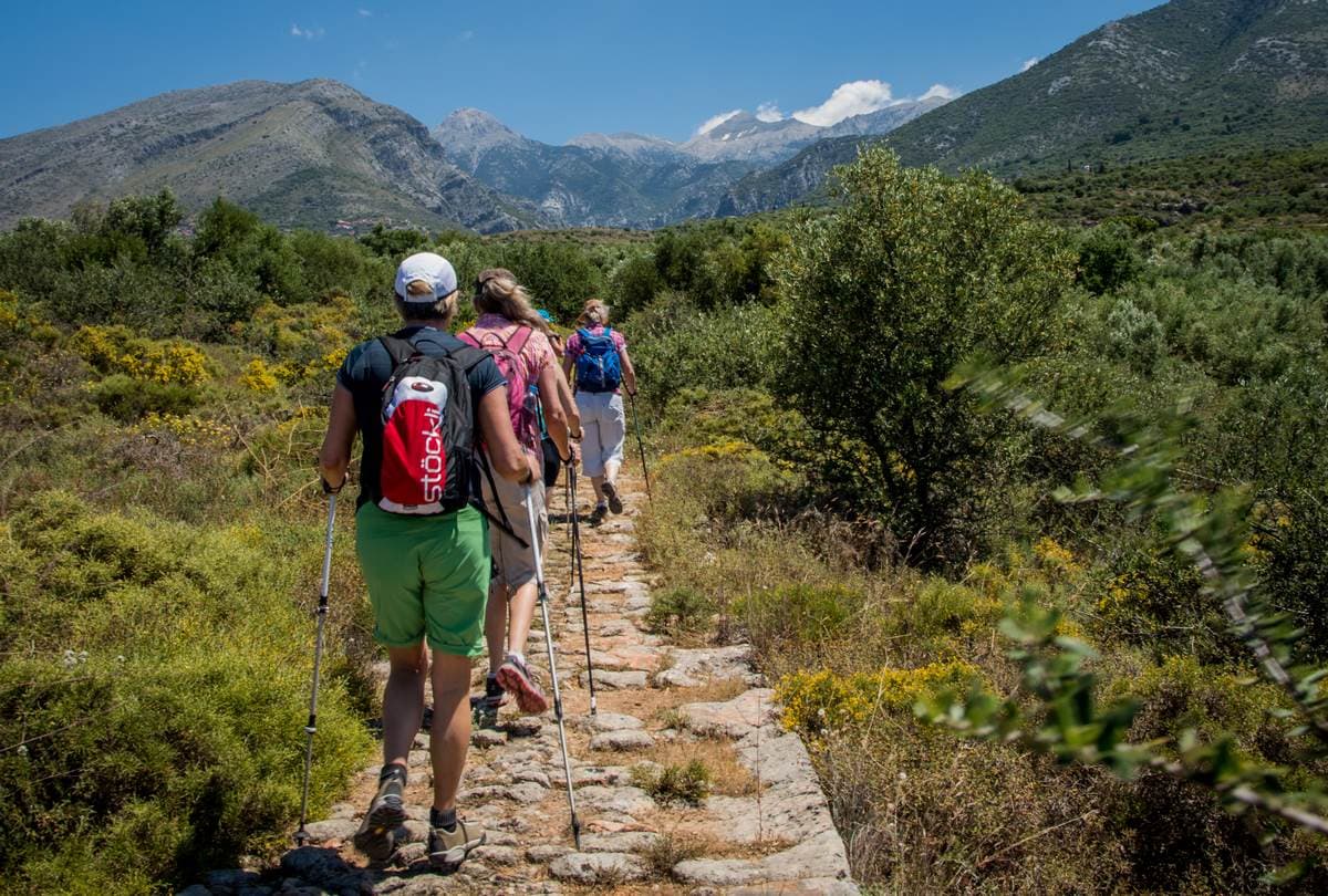 A guided group during one of our hiking tours in Greece walking along an ancient stone path in the Peloponnese.