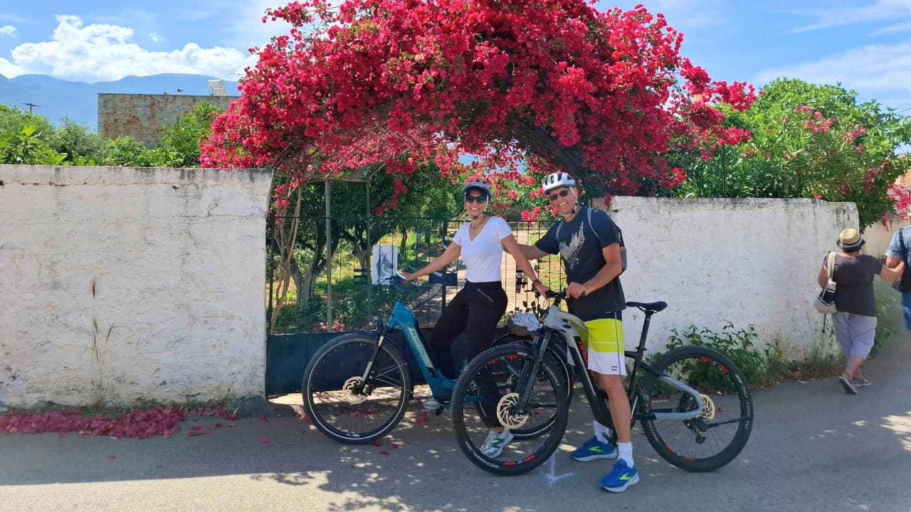 couple with bikes under bougainvillea archway