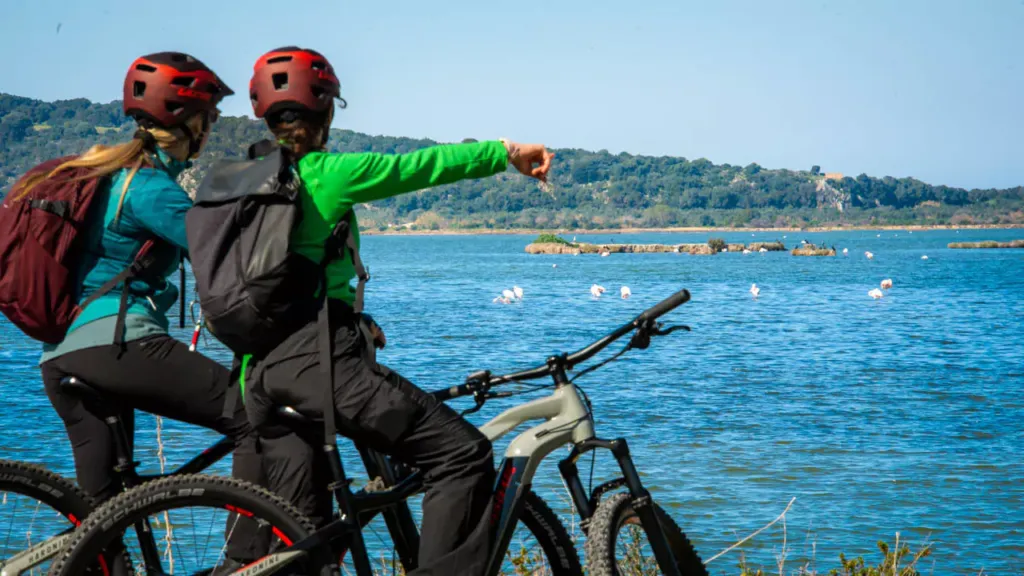 Explore Messinia-Two girls on e-bikes pointing to flamingos at Gialova lagoon