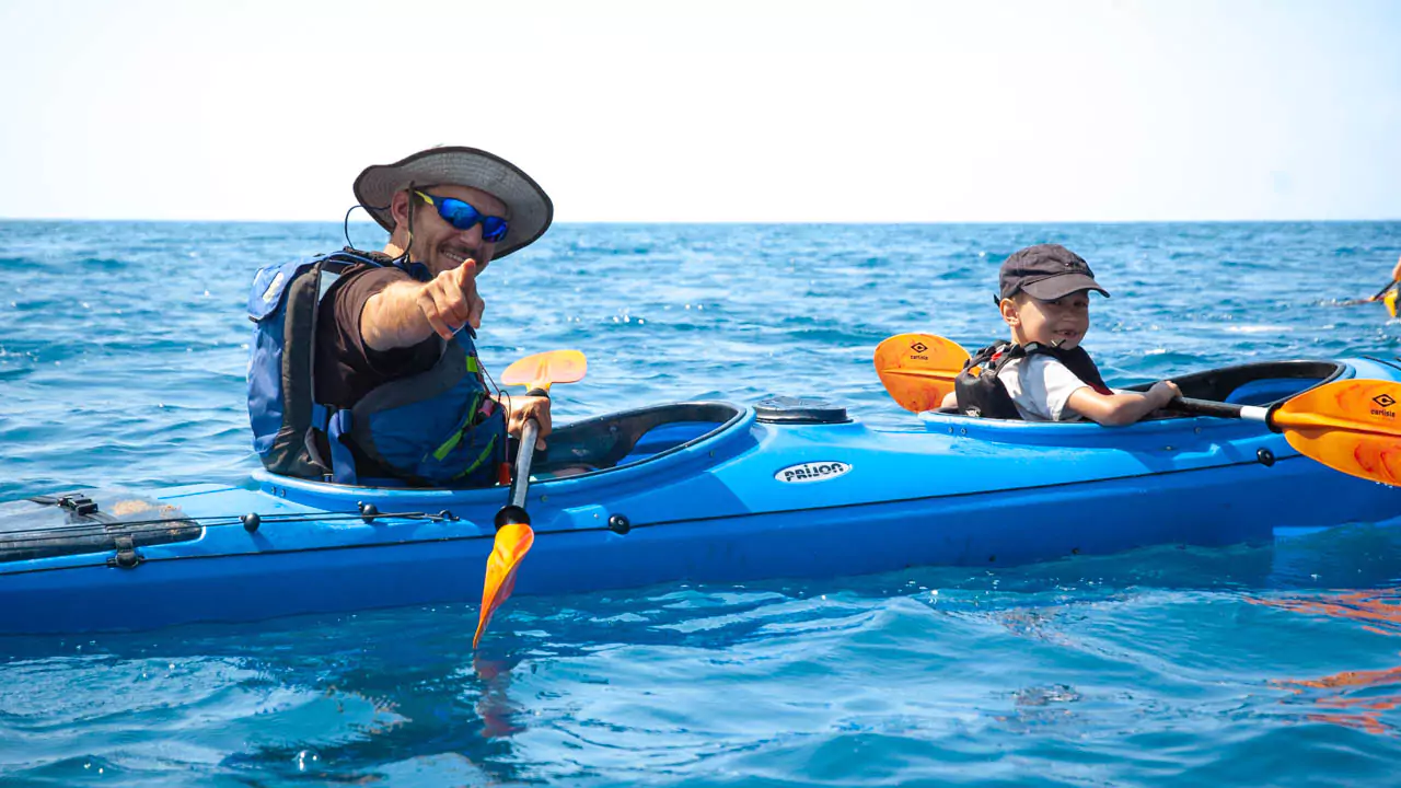 Explore Messinia-A boy and his dad in a Sea Kayak smiling at Navarino Explore Messinia-A boy and his dad in a Sea Kayak smiling at Navarino