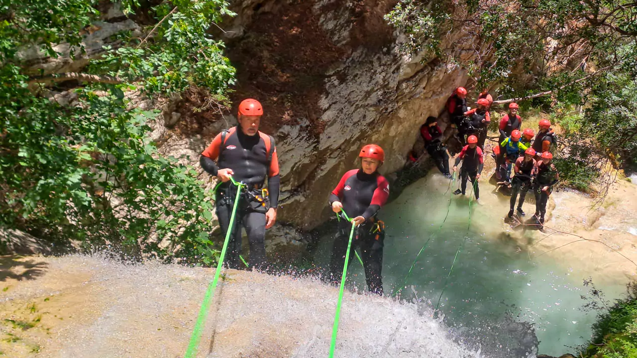 Explore Messinia- Shot in action, as an adventurers carefully rappels down a waterfall at Neda Gorge with water splashing against the surrounding rocks. Explore Messinia- Shot of a harness and rope in action, as an adventurer carefully rappels down a waterfall at Neda Gorge with water splashing against the surrounding rocks. A testament to the safety and expertise of Explore Messinia guides.