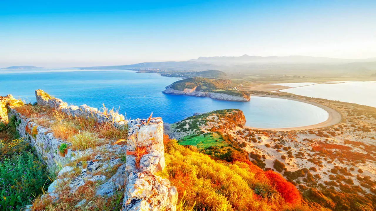 explore messinia voidokoilia from navarino castle 693410354 67caf4df73b8b Explore Messinia-A breathtaking view of Voidokilia Beach from Palaiokastro, showcasing its iconic horseshoe shape, golden sands, and turquoise waters, framed by rugged cliffs and lush greenery.