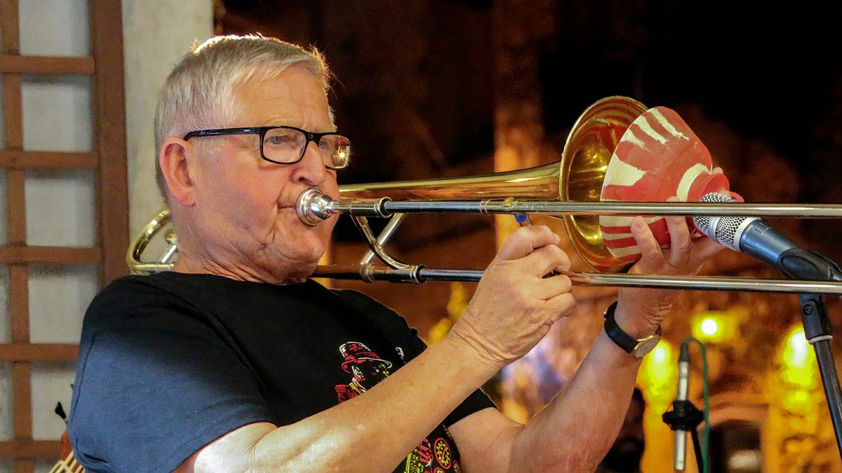 A musician playing a trombone A musician playing a trombone with a red and white striped bell at the Kardamili Jazz Festival in Messinia.